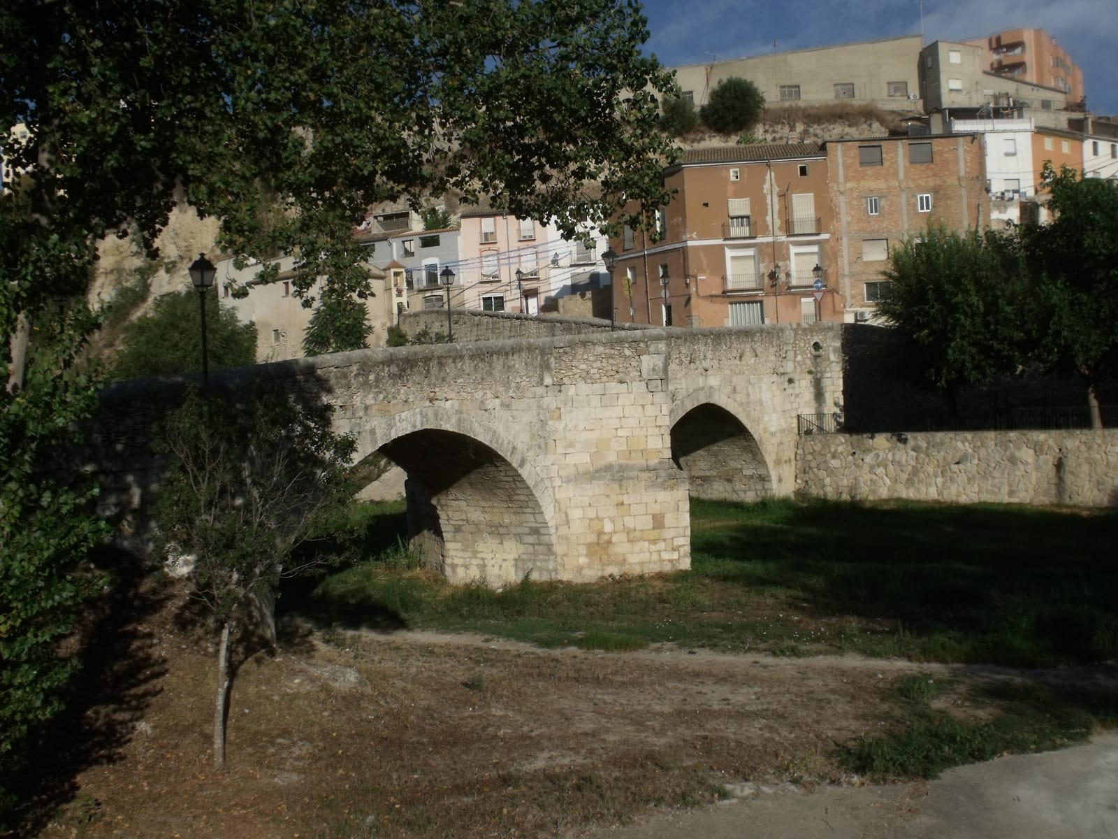 El Pont Vell d'Ontinyent vist des de la llera del Clariano, amb els seus dos arcs de pedra i les cases de la riba darrere